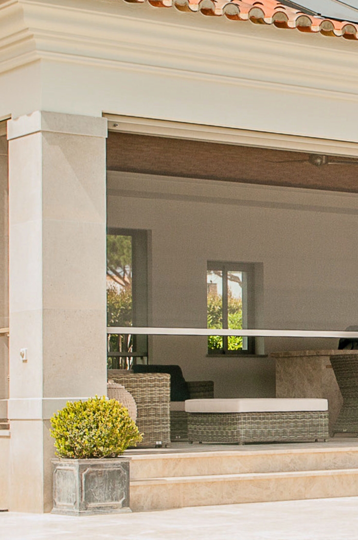 A luxurious outdoor patio with mosquito screens and a view of a well-maintained garden in Algarve, Portugal.