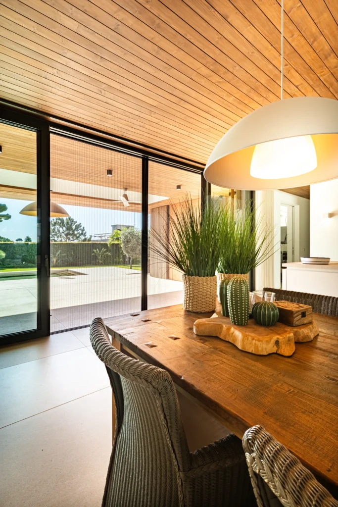 Modern dining area with a view of a patio, featuring retractable Plisse mosquito screens that provide stylish insect protection.